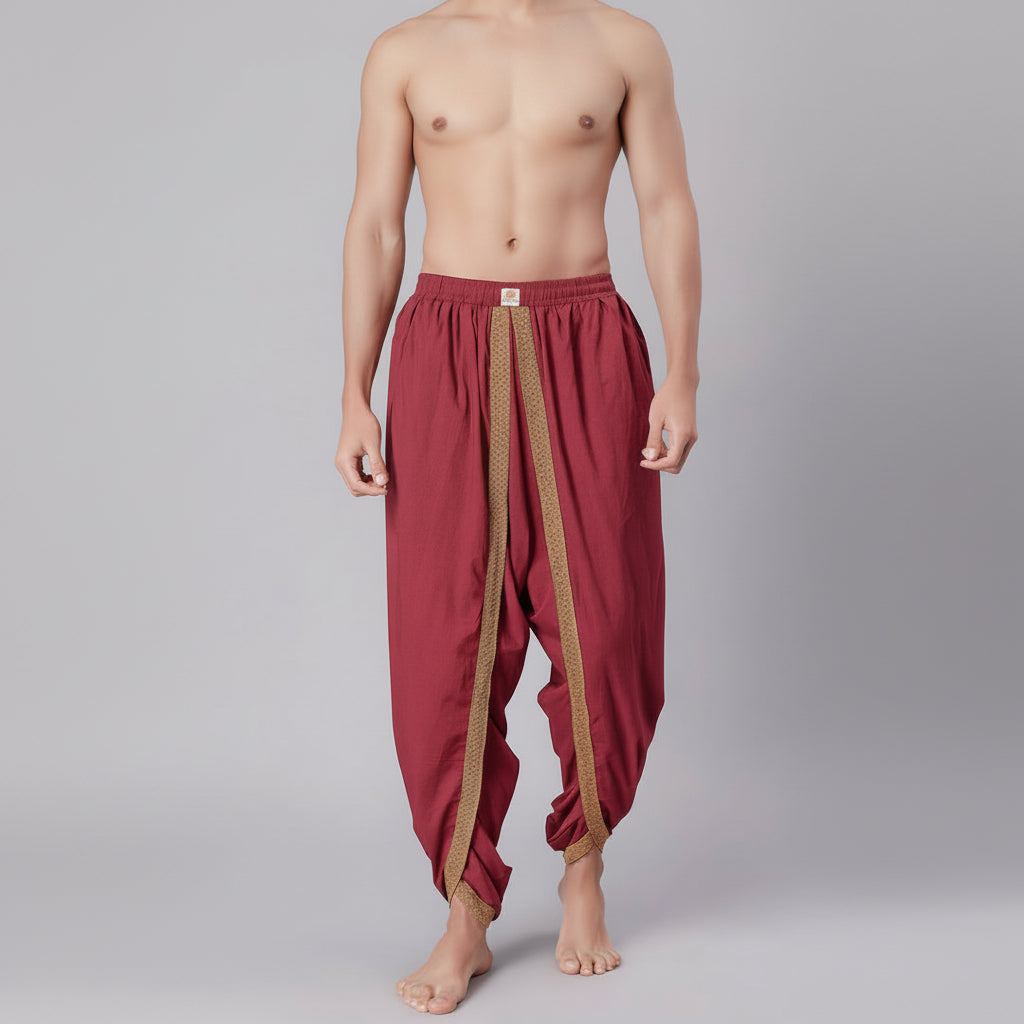 Maroon dhoti pants with gold border worn by a person on a gray background