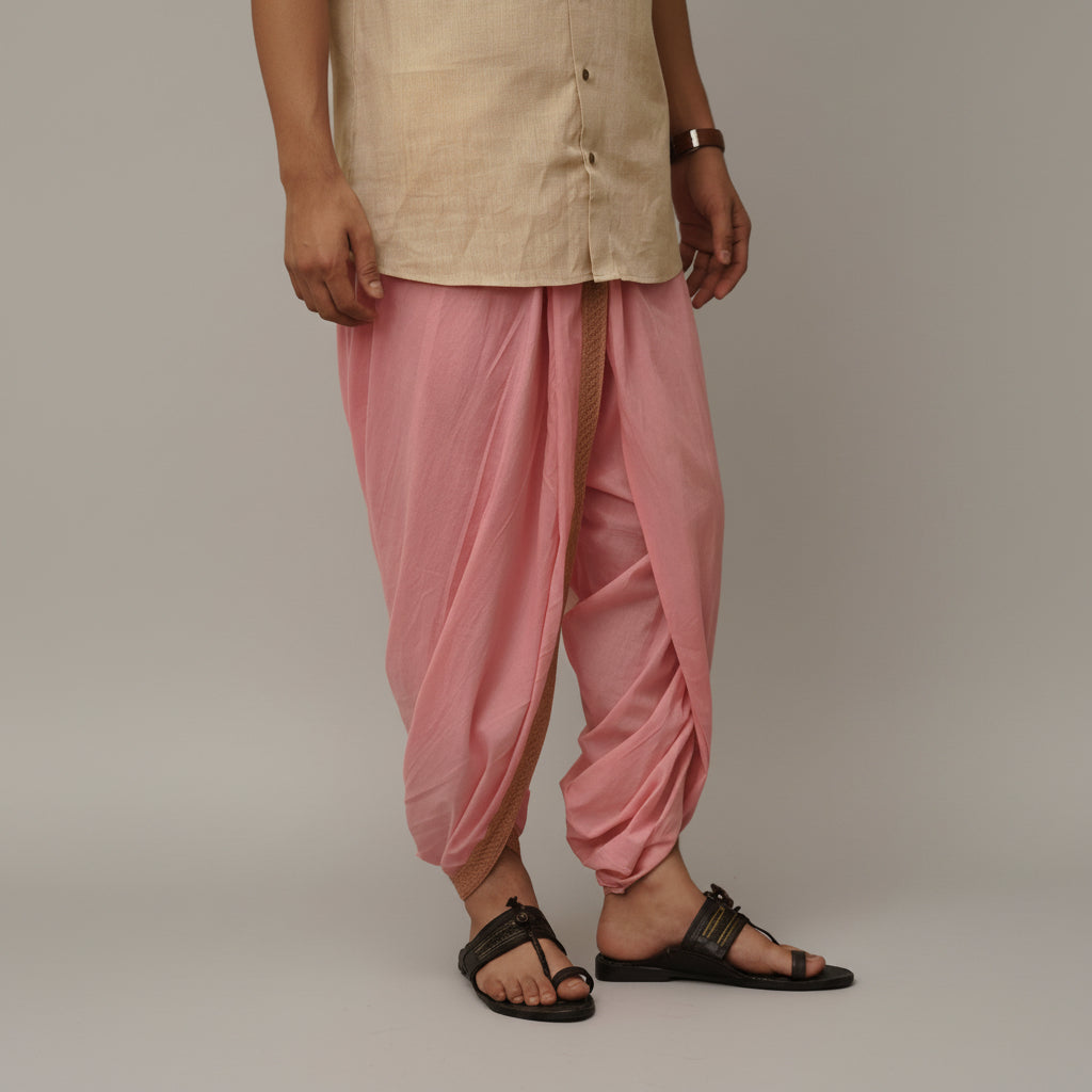 Person wearing a beige kurta with pink dhoti pants on a plain background