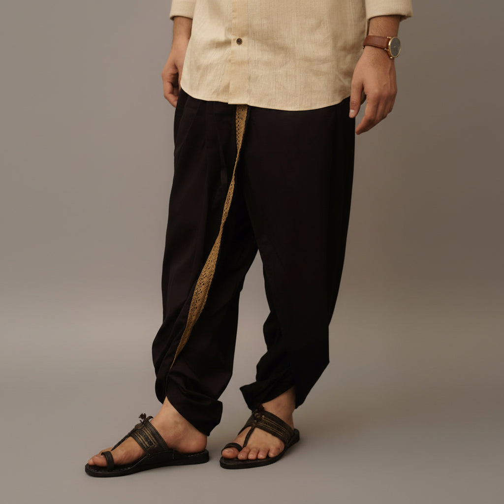 Person wearing black pants with a gold stripe and a beige shirt on a gray background