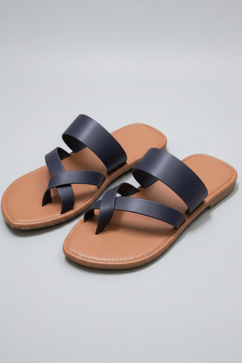 Pair of brown sandals with navy blue straps on a light grey background