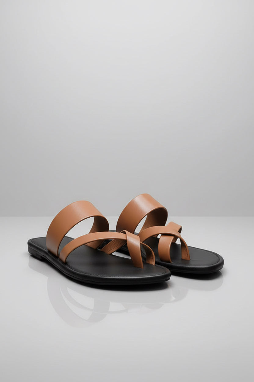 Pair of brown sandals with black soles on a light gray background